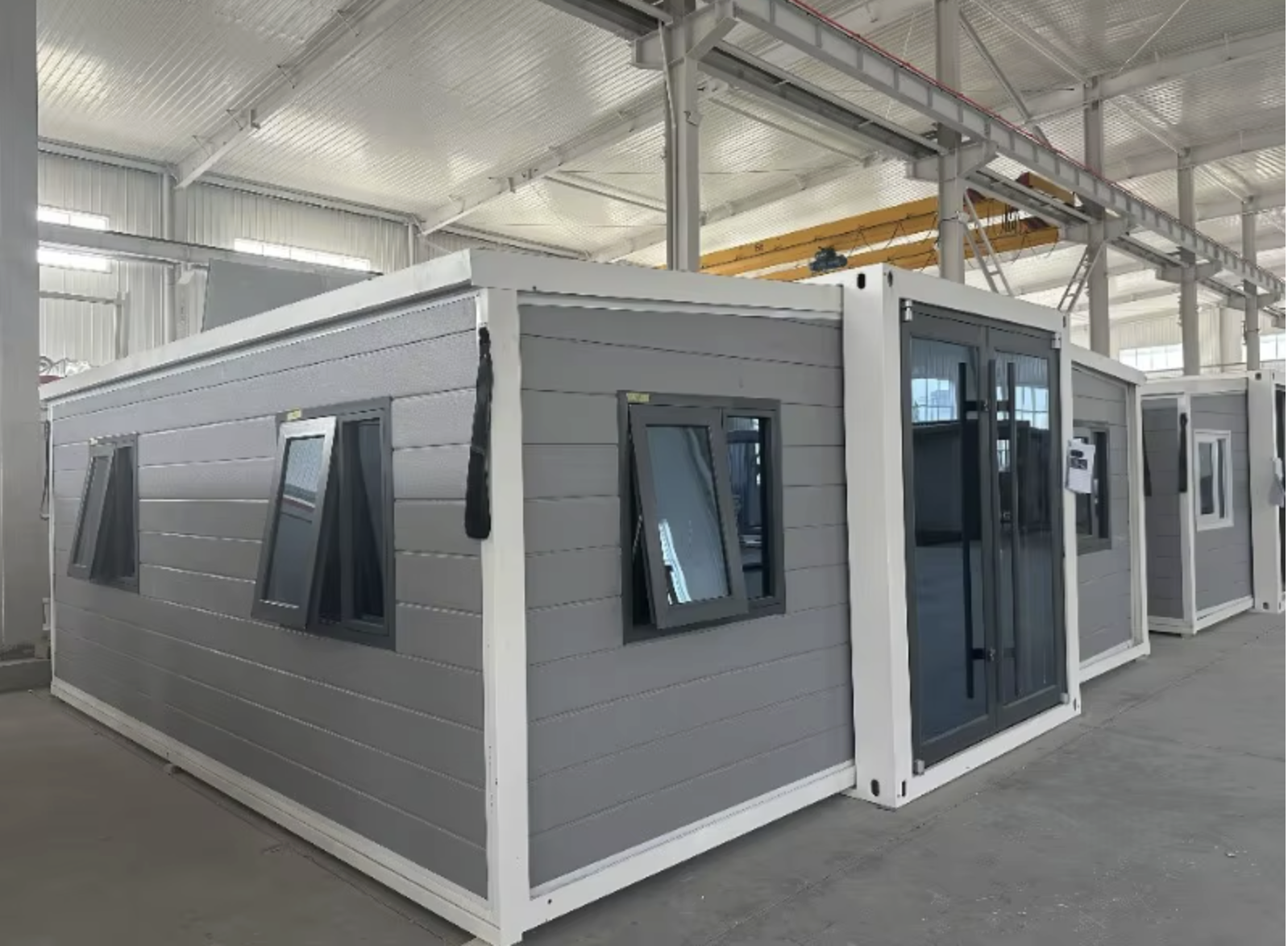 Grey modular container home with white frame in factory